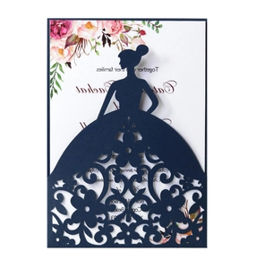 Macro detail of laser-cut floral gown silhouette on dark green wedding invitation card