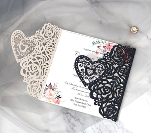 Détail macro d'une invitation fleurie découpée au laser avec paillettes noires chic