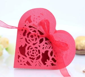 Vue macro d'une boîte à bonbons coeur rouge avec motif rose découpé au laser