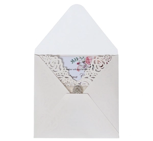 Detailed laser cut rose patterns and sparkling rhinestone buckle on elegant white invitation card