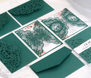 Elegant emerald green laser-cut wedding invitation set with floral inner card on marble