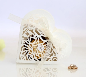 Detail of laser-cut heart candy box with white ribbon bow and rose patterns