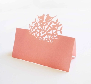 Pink laser-cut tree of life place card featuring birds on branch for wedding tables