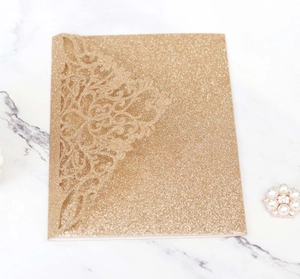 Detailed laser-cut floral pattern on champagne gold glitter wedding invitation cover