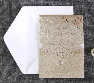 Λεπτομέρεια χρυσής πρόσκλησης γάμου laser cut με σχέδιο τριαντάφυλλο και διαμάντι σταγόνα
