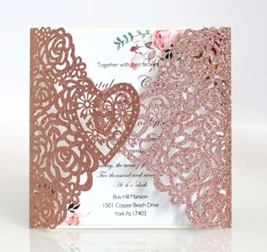 Détail d'invitation de mariage découpée au laser en paillettes or rose avec motifs cœurs