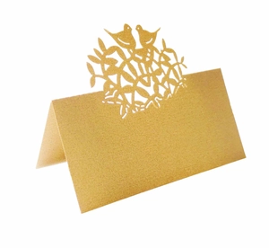 Detail of laser-cut tree of life place card with bird motifs on golden pearlescent paper