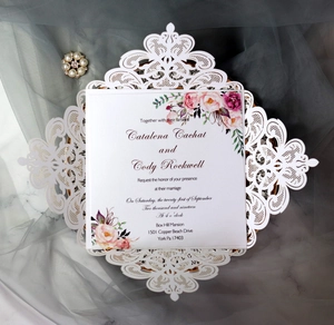 Detailed laser-cut white lace wedding invitation with floral printed inner card on mesh