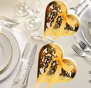 Détail d'une boîte à bonbons coeur dorée avec motifs de roses découpés et ruban satin