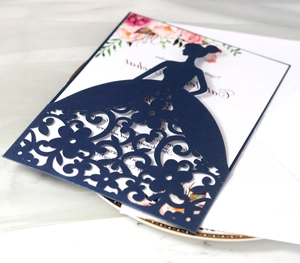 Detail of dark blue laser-cut wedding invitation featuring bride silhouette and floral patterns