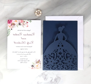 Detailed laser-cut floral wedding invitation with pink flowers and navy blue sleeve