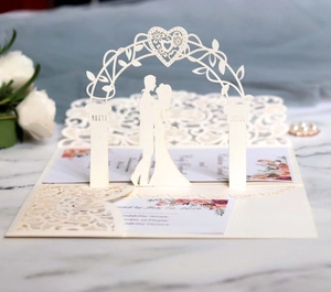Macro view of laser-cut 3D wedding invitation featuring bride and groom silhouette
