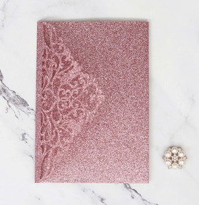 Laser-cut floral glitter wedding invitation cover in rose gold with pearl detail