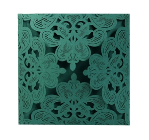 Close-up of laser-cut lace floral pattern on dark forest green wedding invitation card