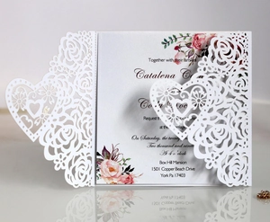 Elegant white laser cut wedding invitation featuring intricate floral and heart patterns
