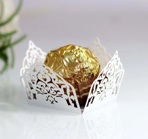 Close-up of laser-cut white favor box with elegant vine patterns for chocolate decor