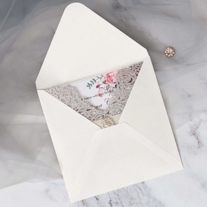 Détail d'invitation de mariage découpée au laser argentée avec strass et motif floral
