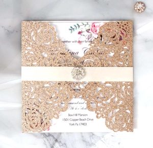 Détail de l'invitation découpée au laser or rose avec boucle en strass et ruban de satin