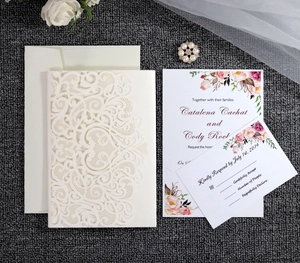 Detail of laser-cut heart lace wedding invitation set with floral inserts and RSVP card