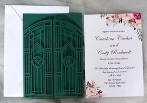 Detail of laser-cut gatefold wedding invitation with floral insert and square envelope
