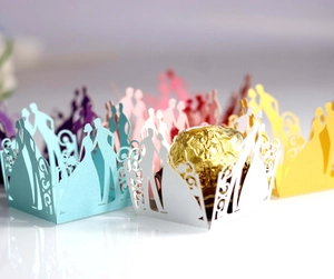 Laser-cut wedding candy boxes featuring bride and groom silhouettes and floral patterns