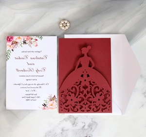 Detail of laser-cut wedding invitation with elegant floral insert and white envelope