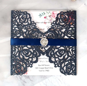 Détail de l'invitation de mariage bleue découpée au laser avec ruban soie et broche strass