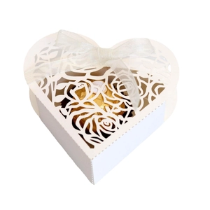 White laser-cut heart favor box with rose patterns and a satin ribbon for weddings