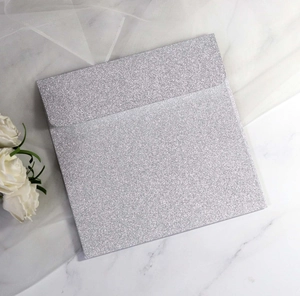 Close-up of glittery silver square envelope for wedding invitations on marble surface