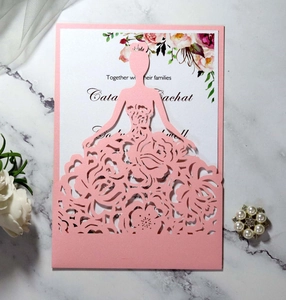 Close-up of laser-cut wedding invitation with bridal dress pattern and floral insert