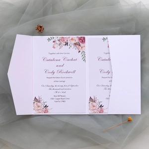 Détail d'une invitation de mariage découpée au laser avec décor floral sur tulle doux