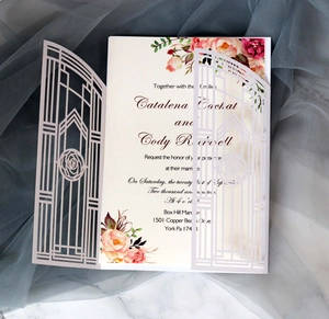 Detail of laser-cut rose hollow invitation with elegant floral inner card on marble