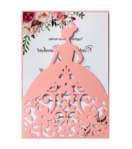 Macro shot of laser-cut peach pink card with elegant lady silhouette and floral patterns