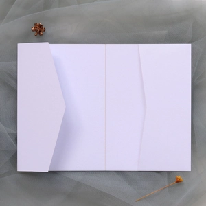 Vue à plat d'une pochette d'invitation blanche à trois volets sur maille grise et fleur