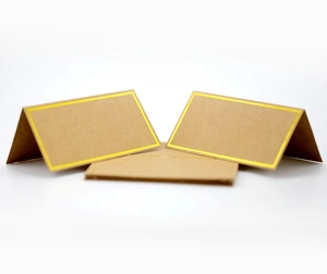 Macro view of kraft paper place cards with gold foil border and tent-fold structure