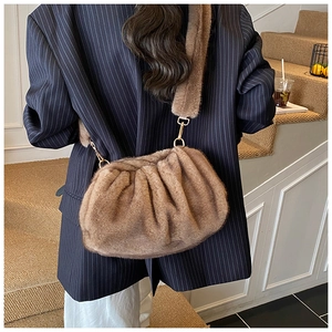 Detail view of brown faux fur cloud bag with soft pleats and elegant gold metal buckles