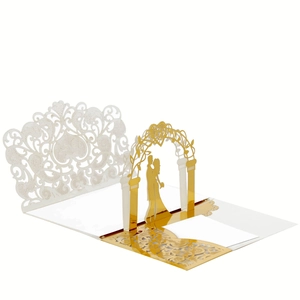 Macro view of 3D laser-cut wedding card featuring golden arch and bridal couple silhouette