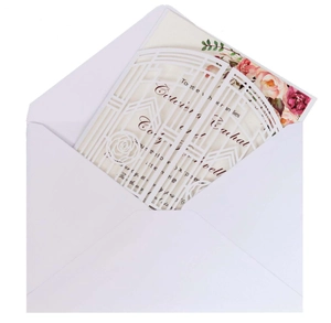 Macro view of laser cut floral invitation cover with cream rose print insert