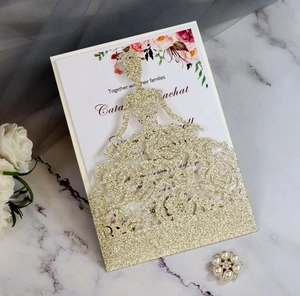 Macro view of laser-cut glitter gold dress invitation with pink rose floral inner card