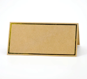 Macro shot of folded kraft paper place card with elegant black and gold foil border