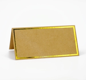 Close-up of a brown kraft paper place card with an elegant gold foil border finish