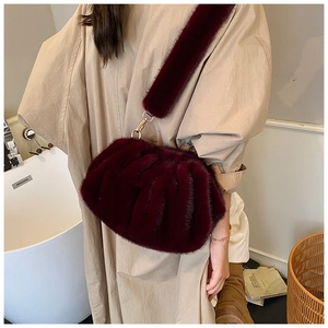 Detail view of burgundy plush faux fur cloud bag with soft pleated texture and wide strap