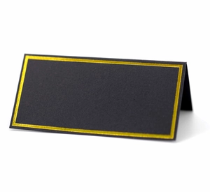 Close-up of black wedding place card with elegant gold foil borders and folded design