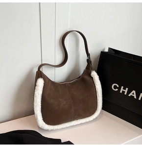 Close-up of brown suede hobo bag with white faux fur trim and thin shoulder strap
