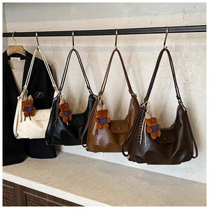 Detail view of stylish hobo bags in four colors with cute brown plush bear charms