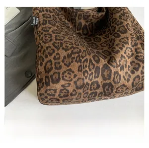 Close-up of leopard print tote bag fabric with side logo and matte suede texture