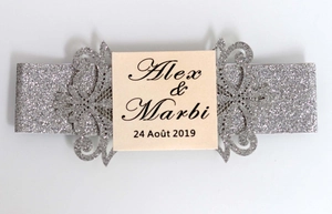 Close-up of laser cut silver glitter belly band with custom wedding invitation card