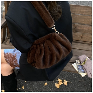 Detail of dark brown faux fur cloud bag with soft pleated texture and gold hooks