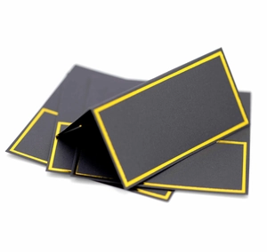 Close-up of black matte table place cards with elegant gold foil borders in tent fold style