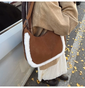 Detailed view of brown suede shoulder bag with thick white faux fur trim in autumn setting